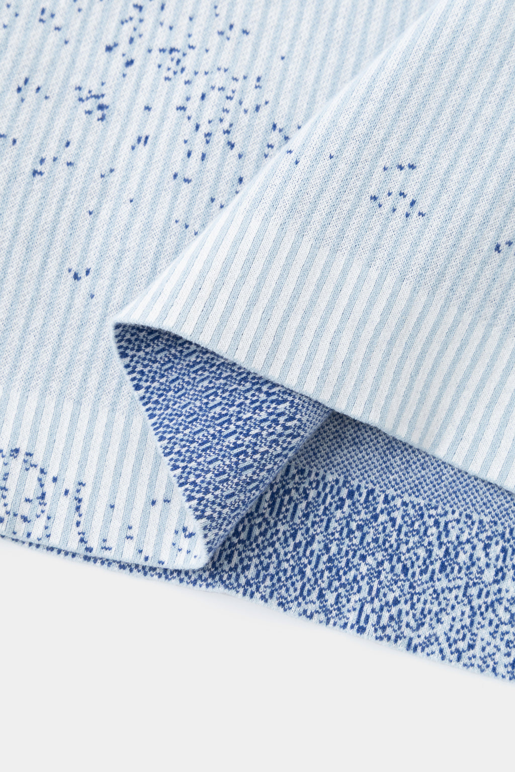 Close-up of the hem folded back, showing the reverse of the knit and the blue speckle.