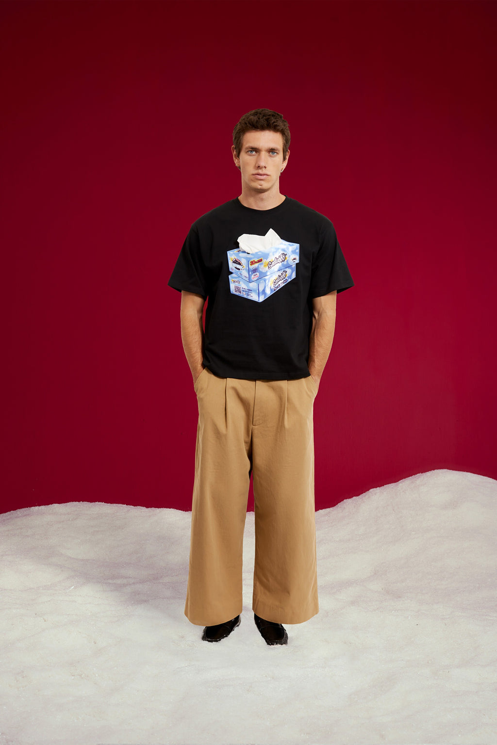 Tissue Paper Box Tee in black, printed with a tissue box graphic at the chest. Worn on a model, full-length front view.