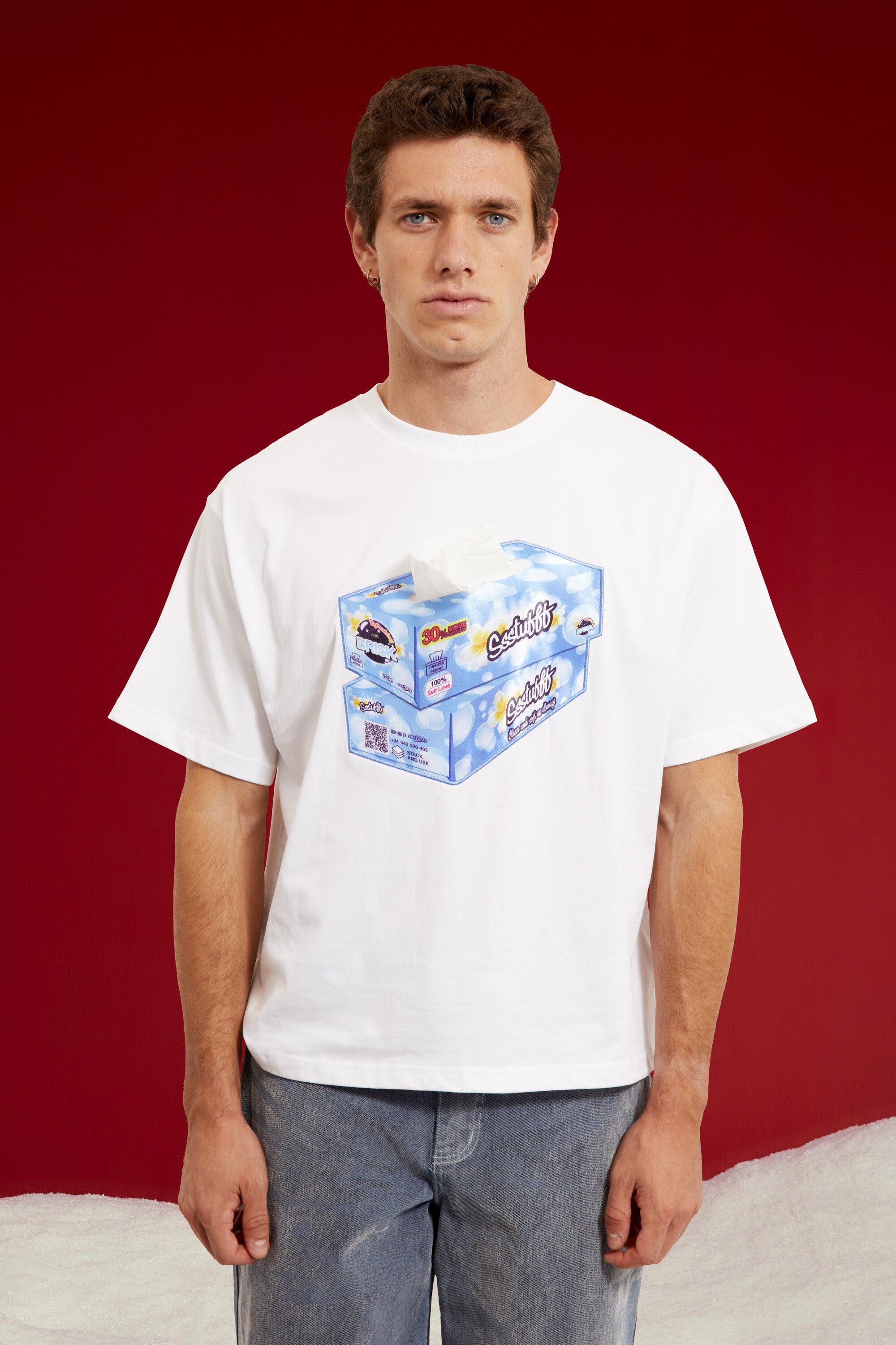Tissue Paper Box Tee in white, printed with a large tissue box graphic at the chest. Worn on a model, waist-up view.