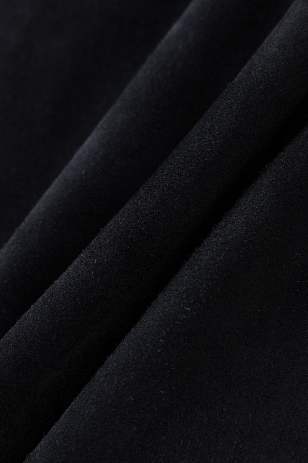 Black genuine sheepskin suede, fabric detail.