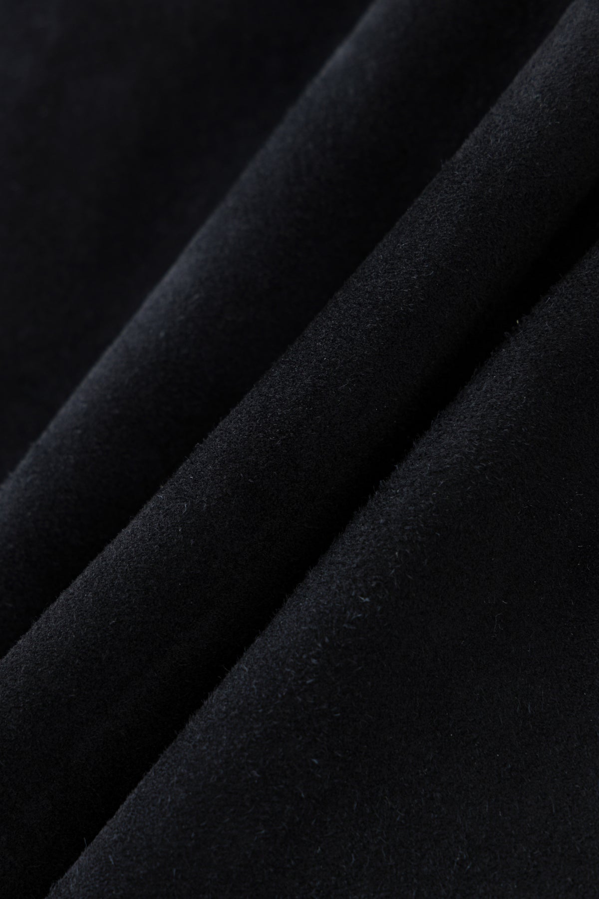 Black genuine sheepskin suede, fabric detail.