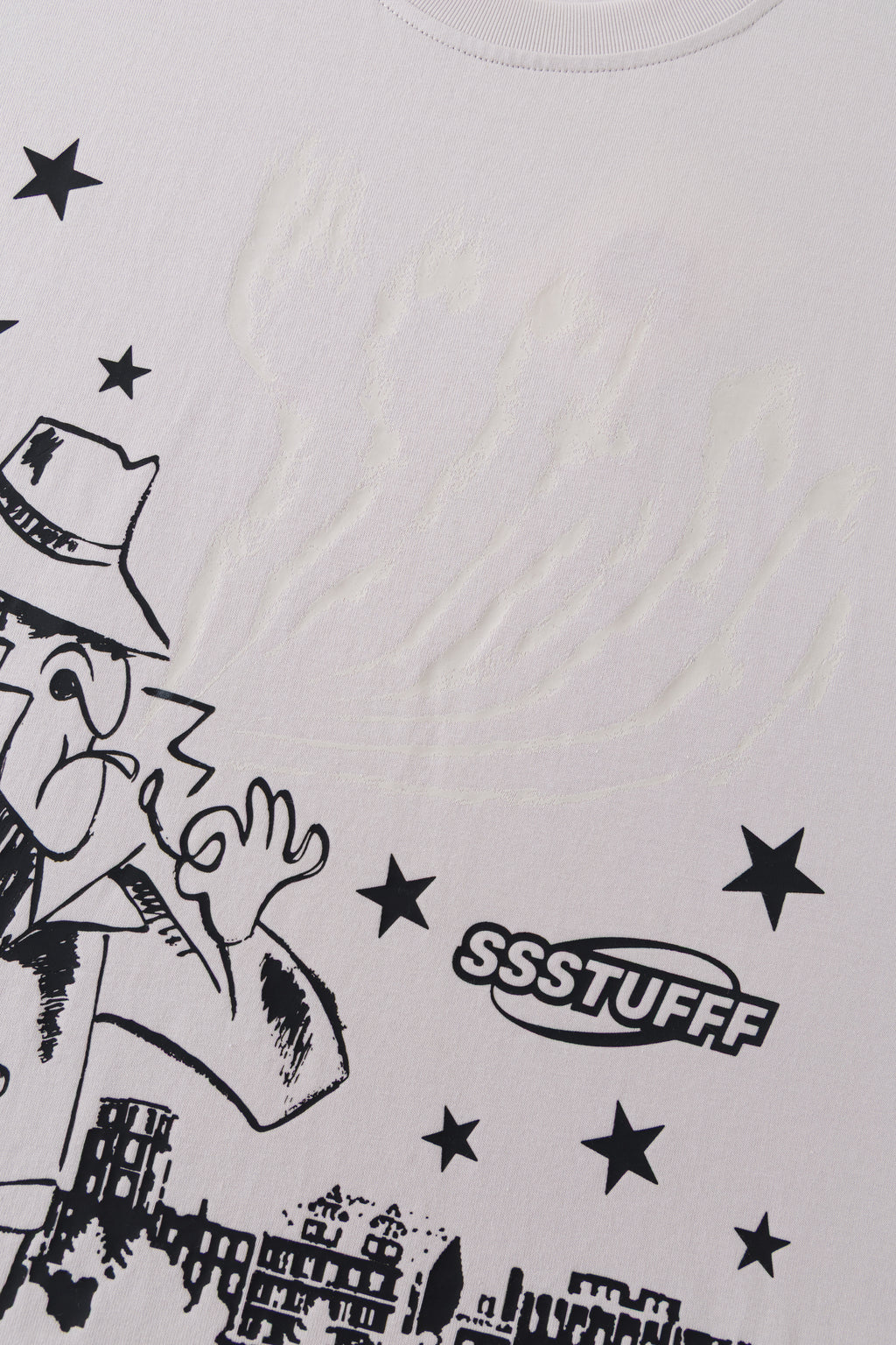 Close-up of the detective print with the SSSTUFFF logo and stars, the UV smoke above him showing as a faint raised texture.