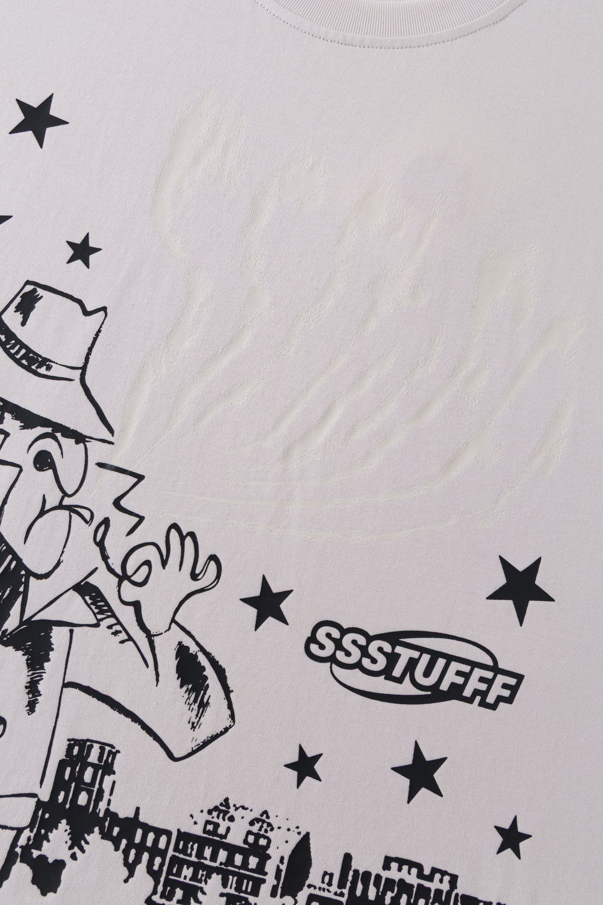 Close-up of the detective print with the SSSTUFFF logo and stars, the UV smoke above him showing as a faint raised texture.