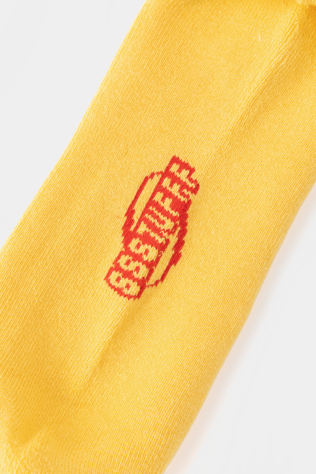 Detail of the red SSSTUFFF logo knitted into the yellow rib.
