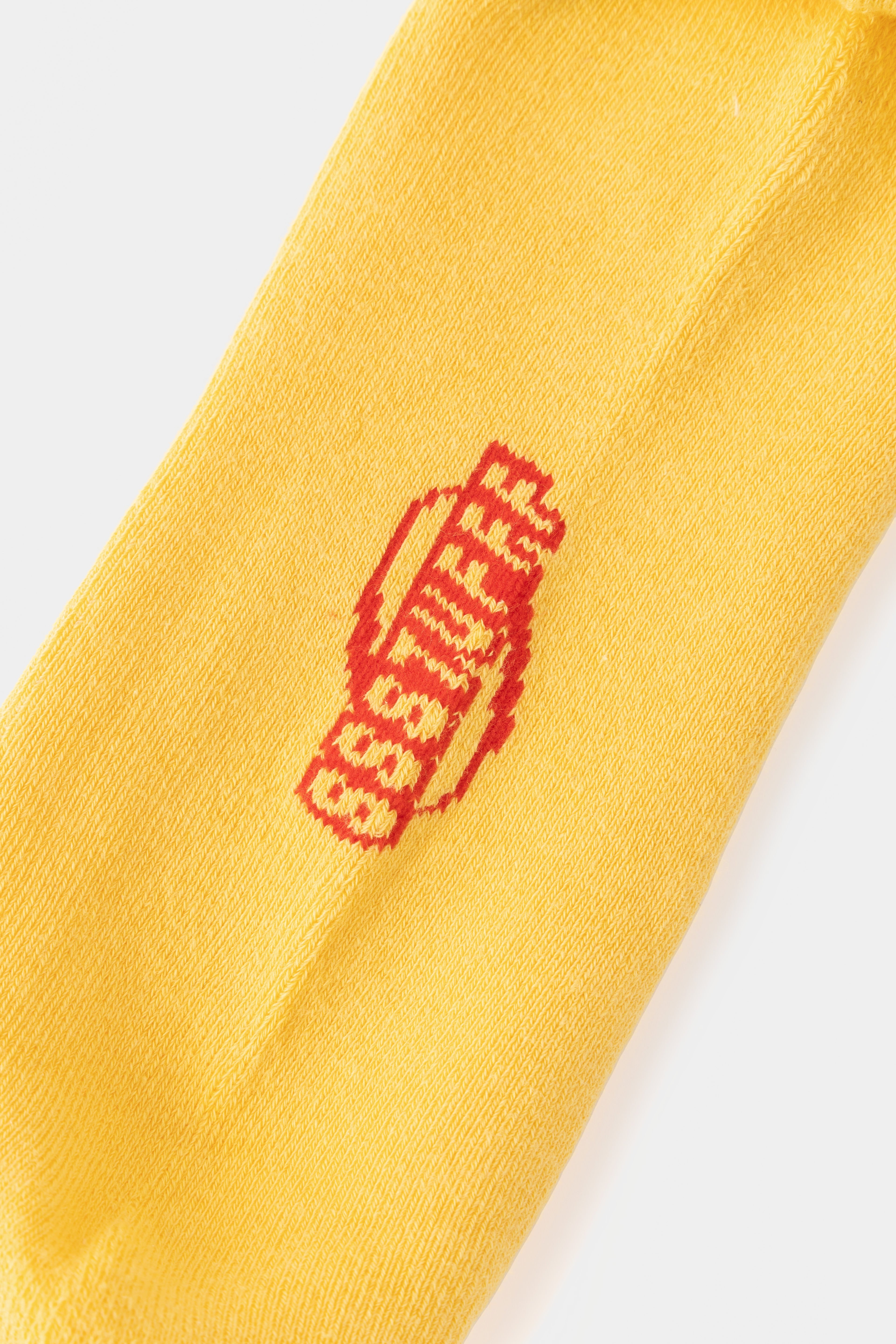 Detail of the red SSSTUFFF logo knitted into the yellow rib.