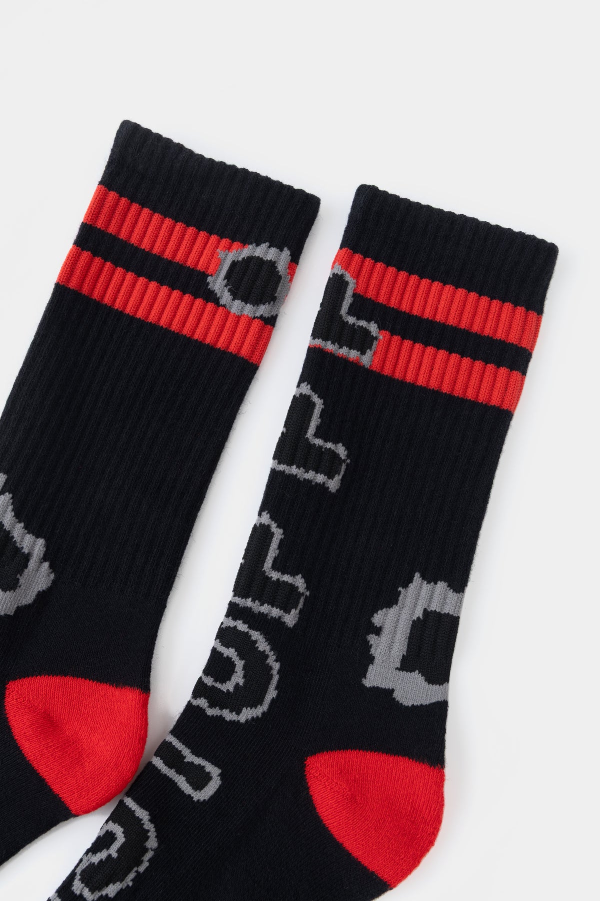 Close-up of the ribbed cuffs with two red stripes and the grey knitted bullet holes.