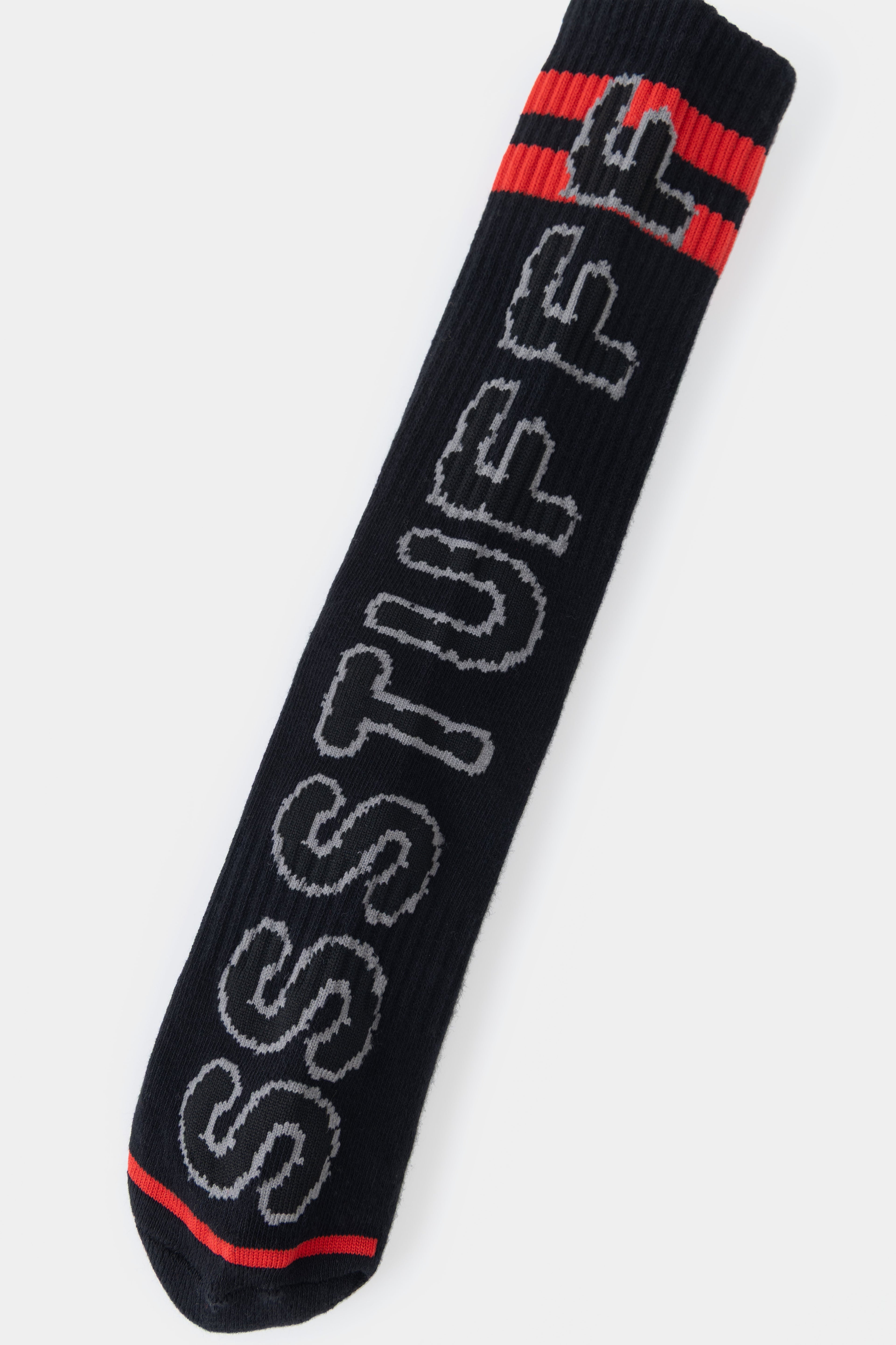 Detail of the SSSTUFFF lettering knitted down the side of the sock, with the red toe below.