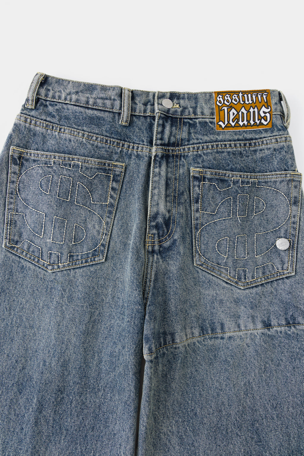 Close-up of the back pockets with embroidered $ logos and the Ssstufff Jeans label at the waistband.