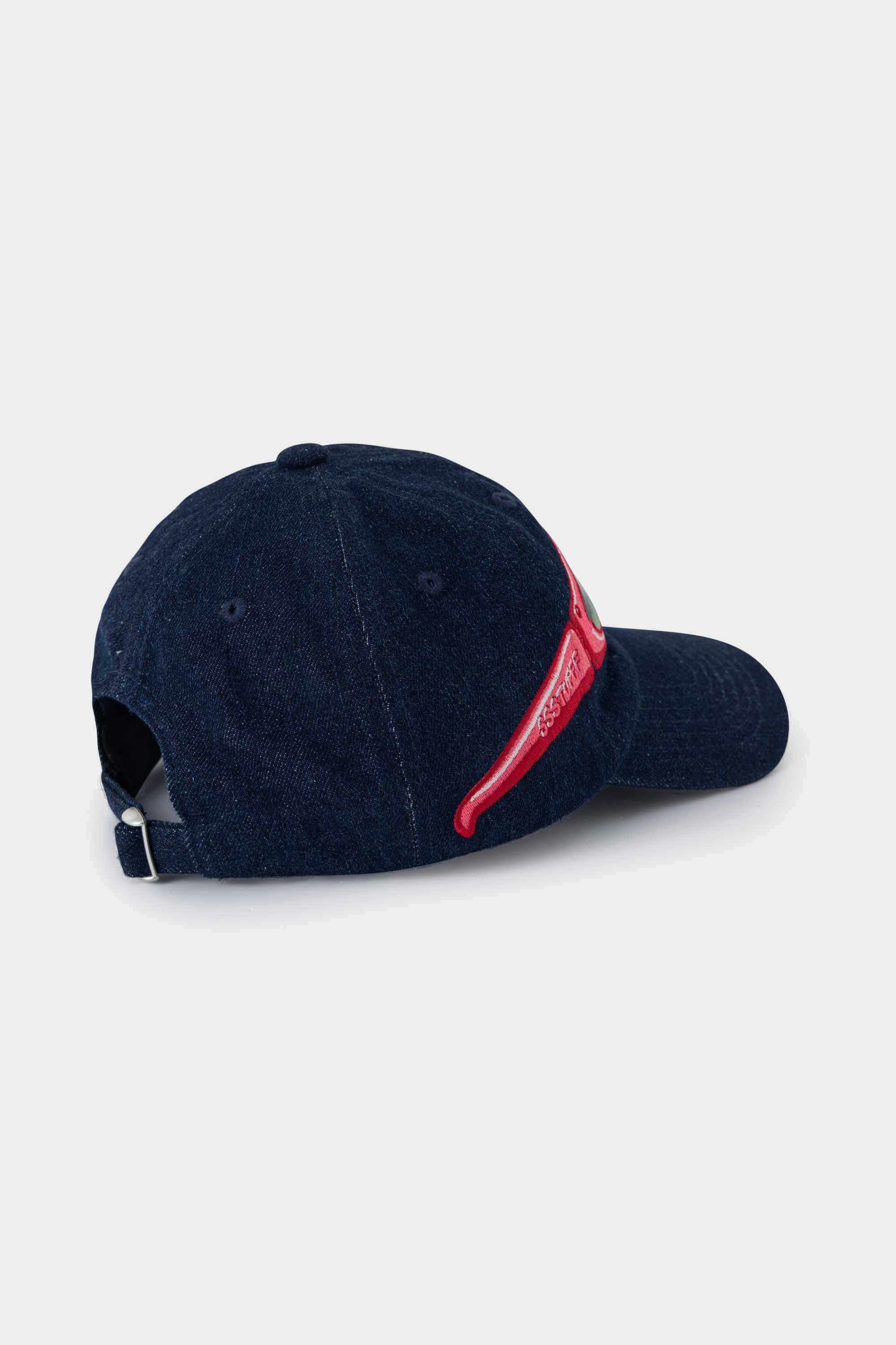 Side view of the denim Lenticular Sunglasses Cap, the red glasses patch wrapping onto the brim