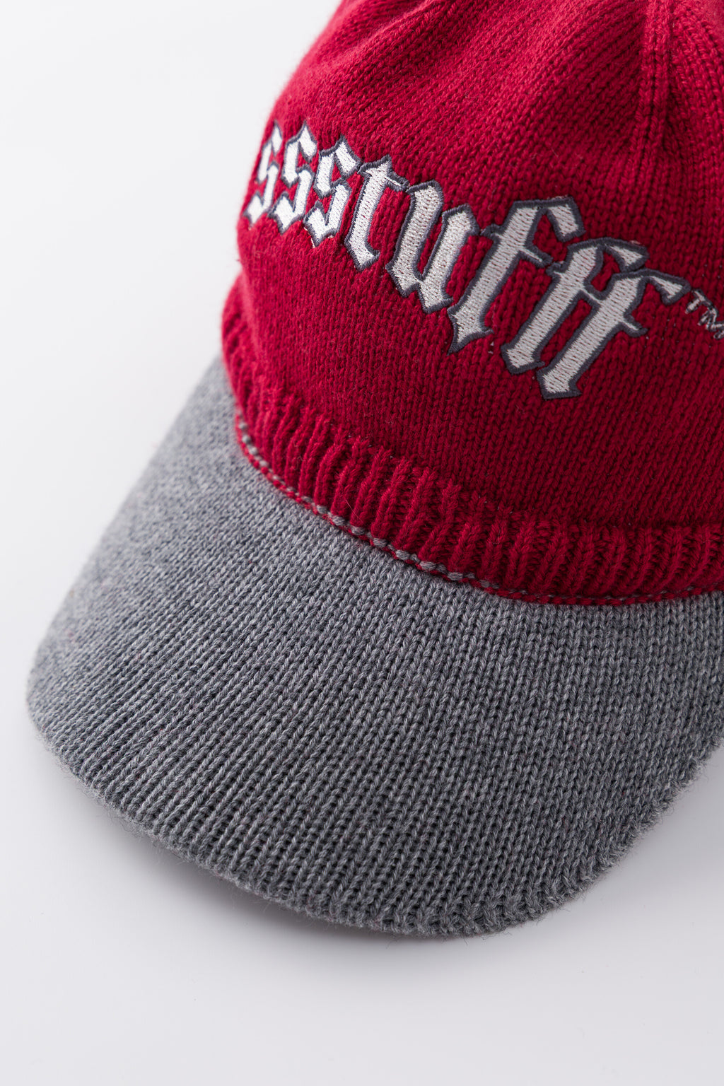 Close-up of the gothic ssstufff embroidery above the contrast grey knitted brim.