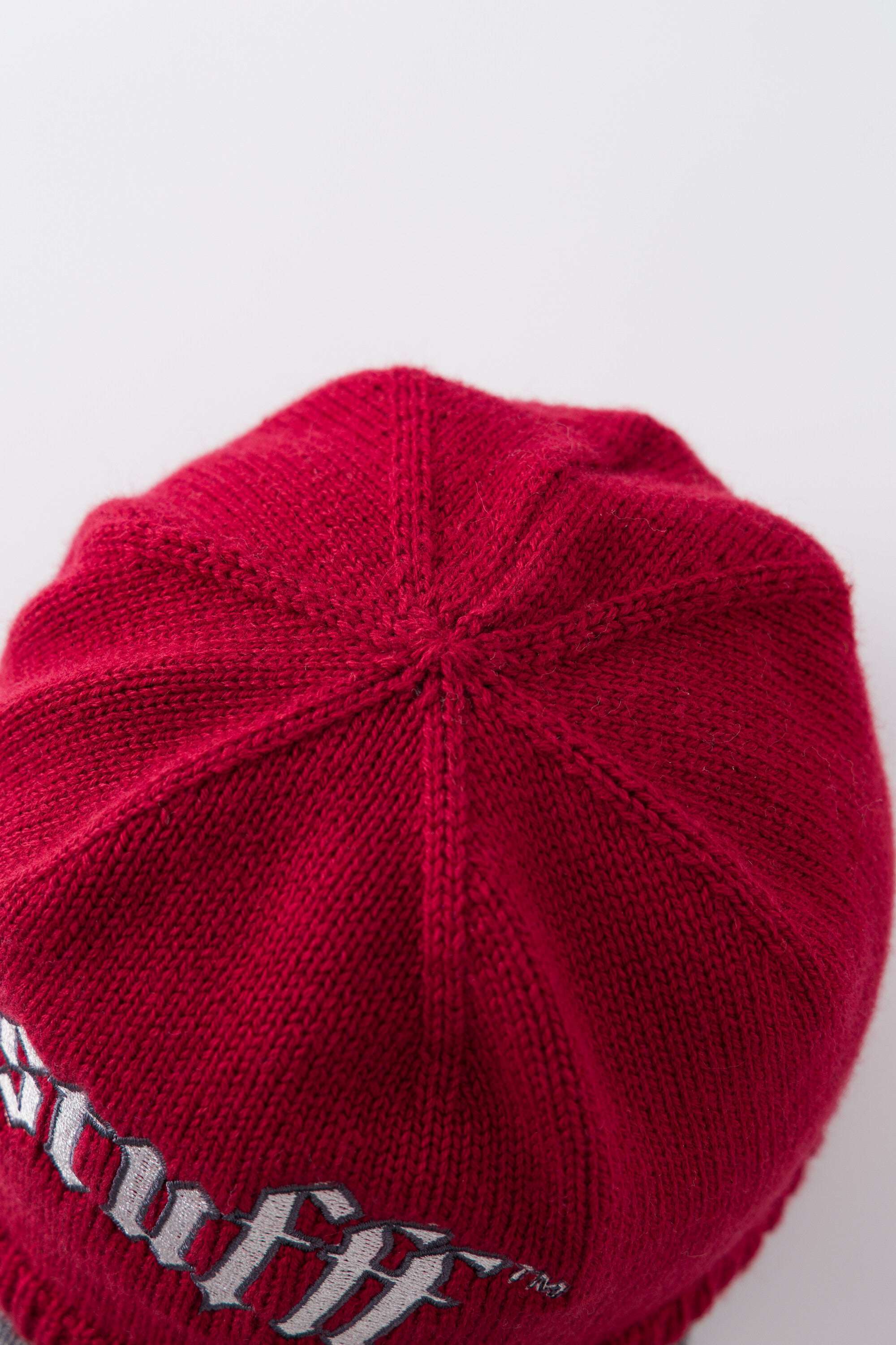 Top view of the red Knitted Cap showing the panelled knitted crown.