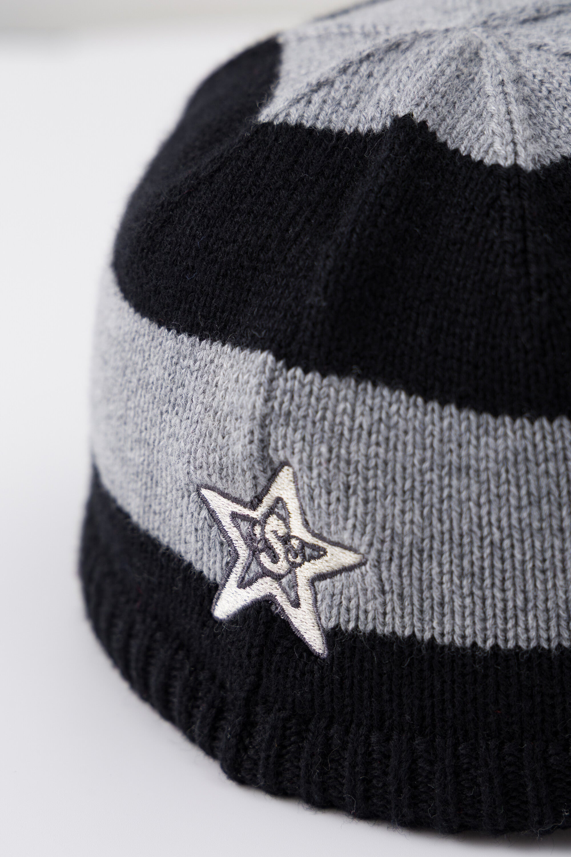 Detail of the embroidered star patch on the side of the Striped Knitted Cap.